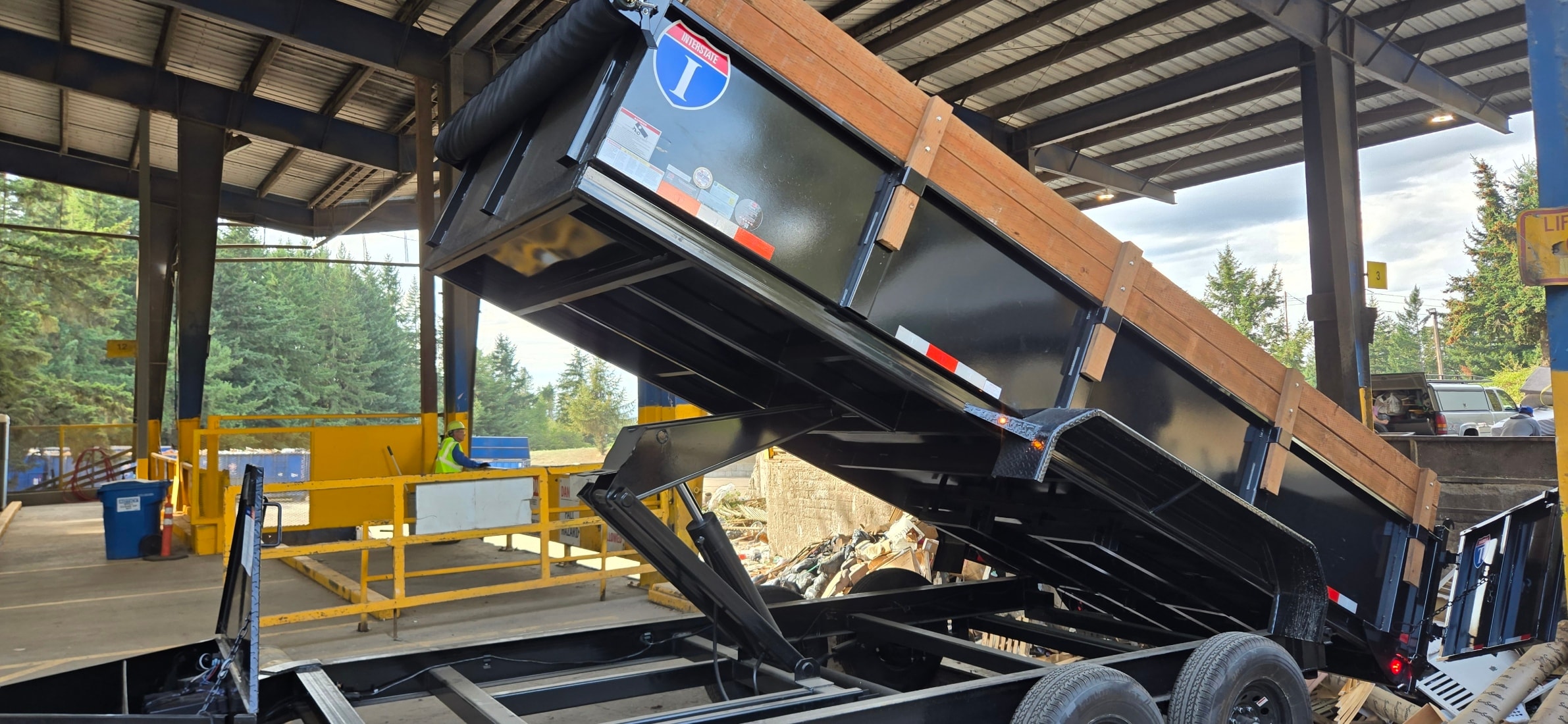 Waste Slayer Hauling 7x16 dump trailer dumping at transfer station